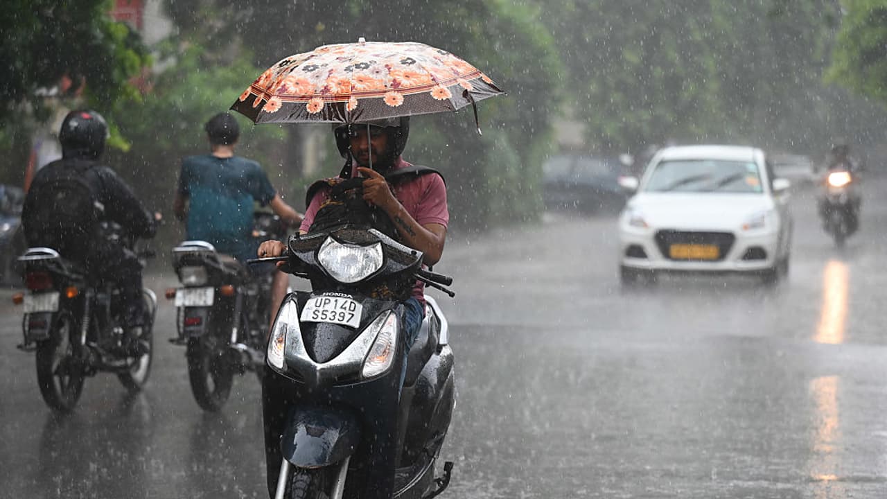 A commuter riding through rain in Delhi A commuter riding through rain in Delhi