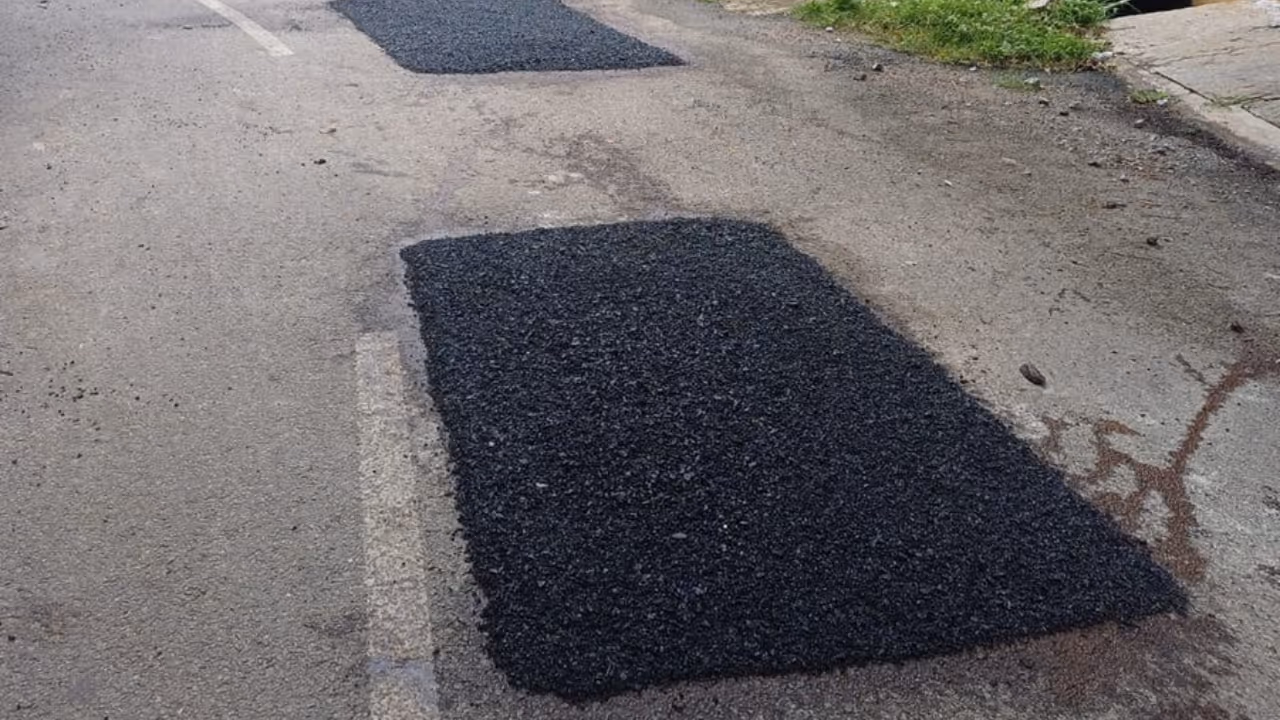 Workers filling potholes with cold mix asphalt in Bengaluru