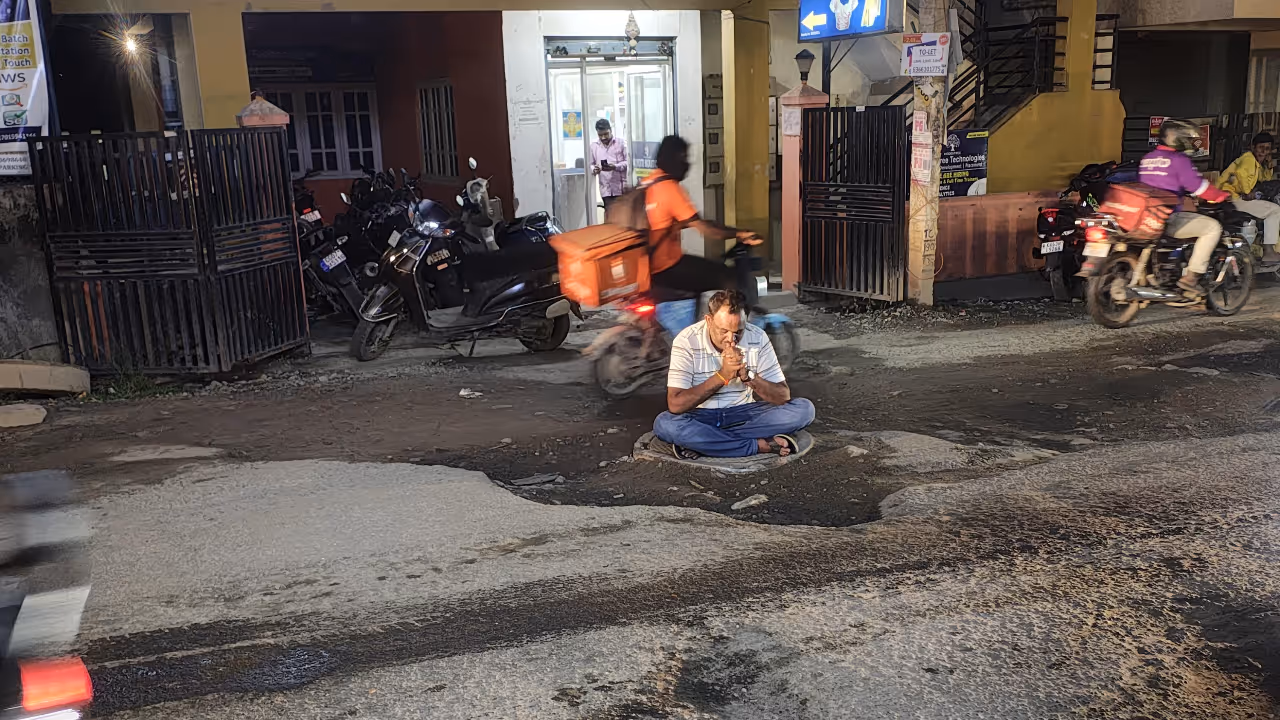 Bengaluru resident protests dangerous potholes by sitting on busy road