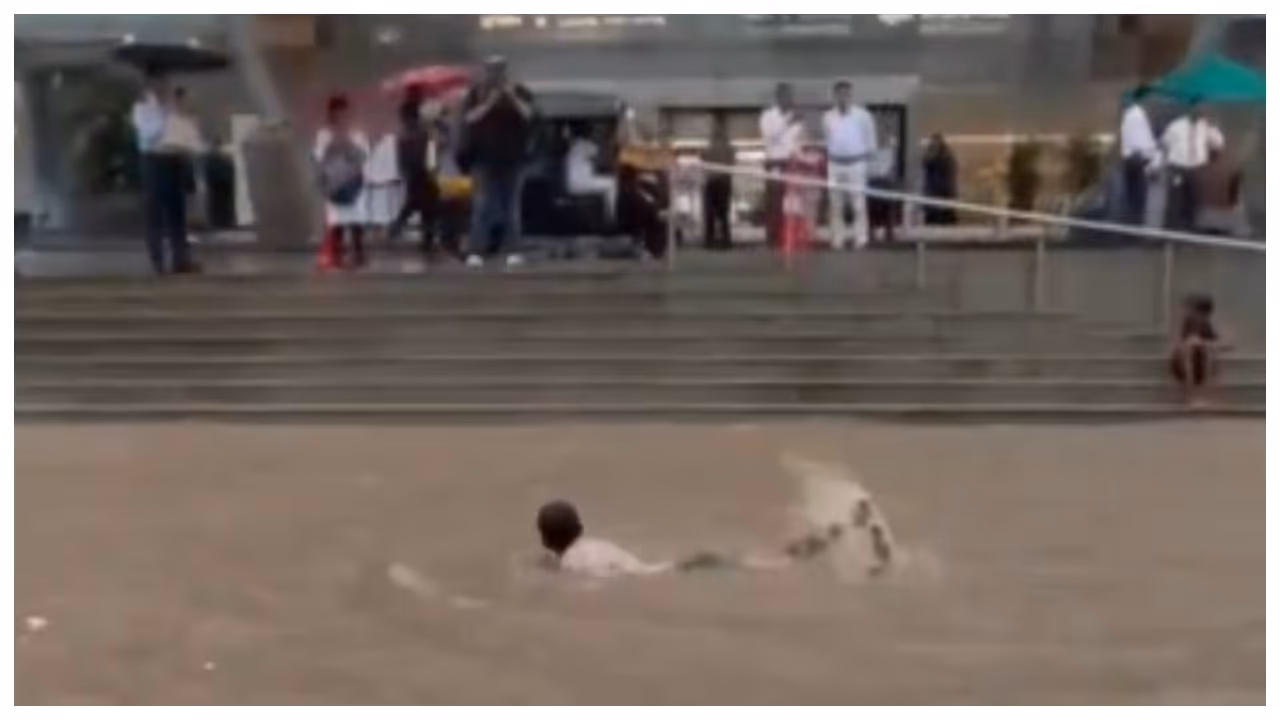 boy swimming in mumabi road after heavy rain