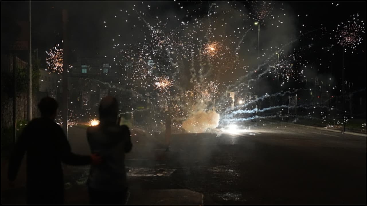 Protesters throw fireworks at police in ireland Protesters throw fireworks at police in ireland