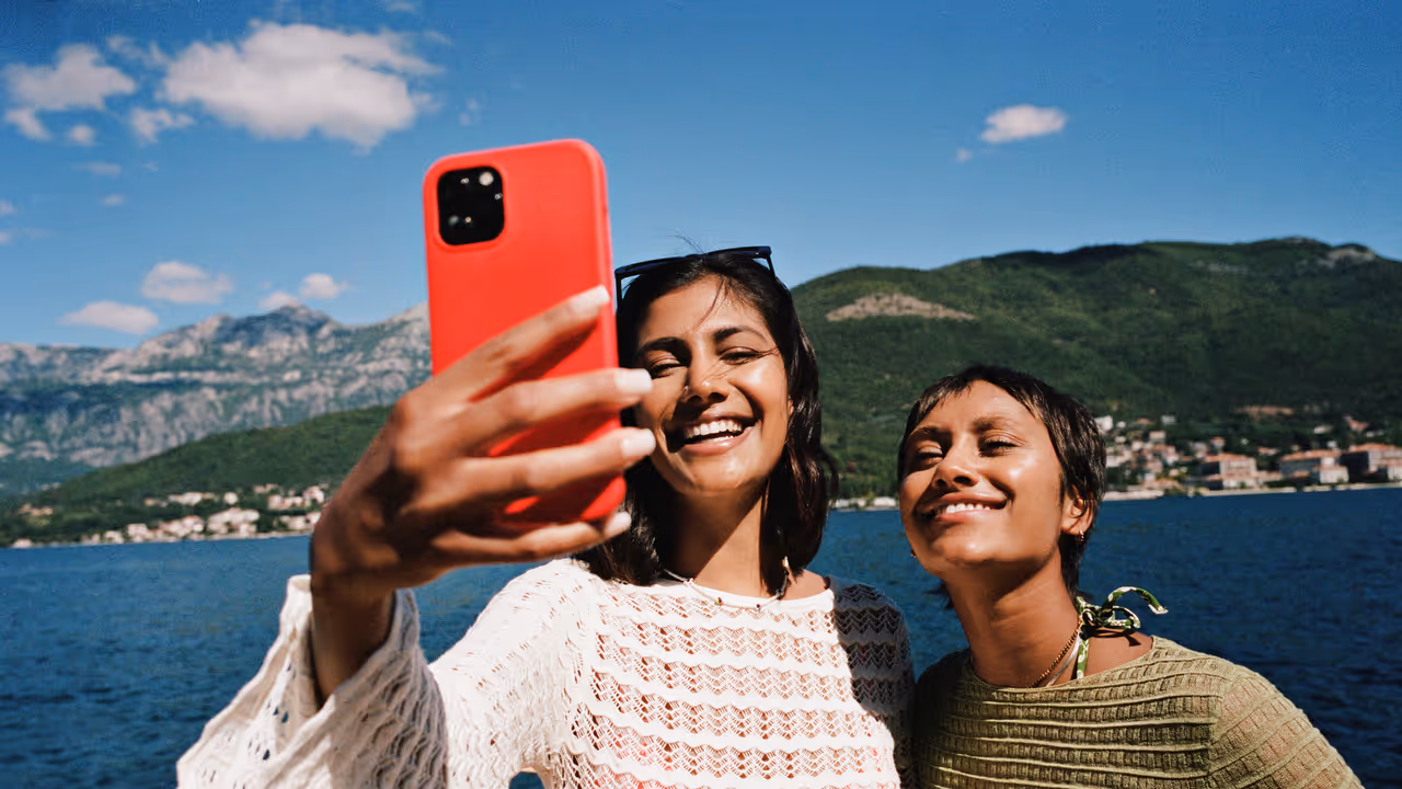 Woman taking selfie with female friend on smart phone Woman taking selfie with female friend on smart phone