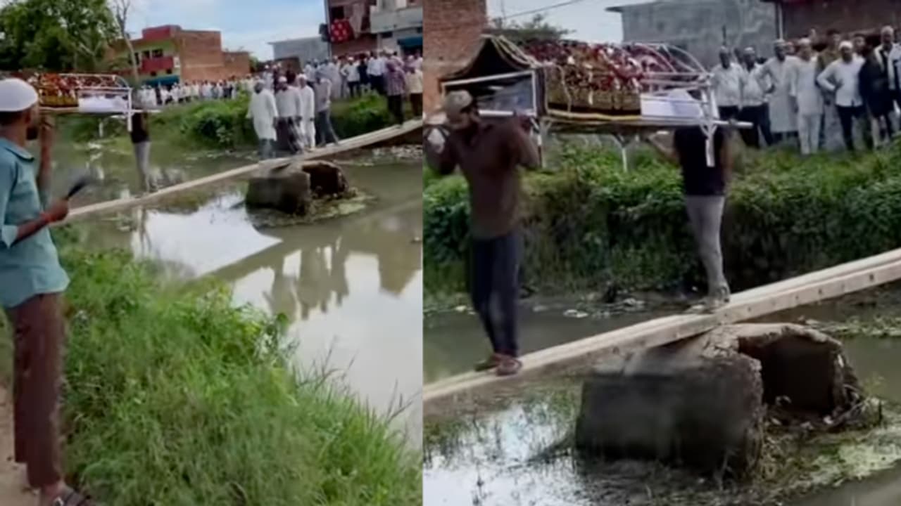 Prayagraj Video Shows Funeral Bier Carried Across Canal on Two Wooden Poles, Sparks Safety Concerns Prayagraj Video Shows Funeral Bier Carried Across Canal on Two Wooden Poles, Sparks Safety Concerns