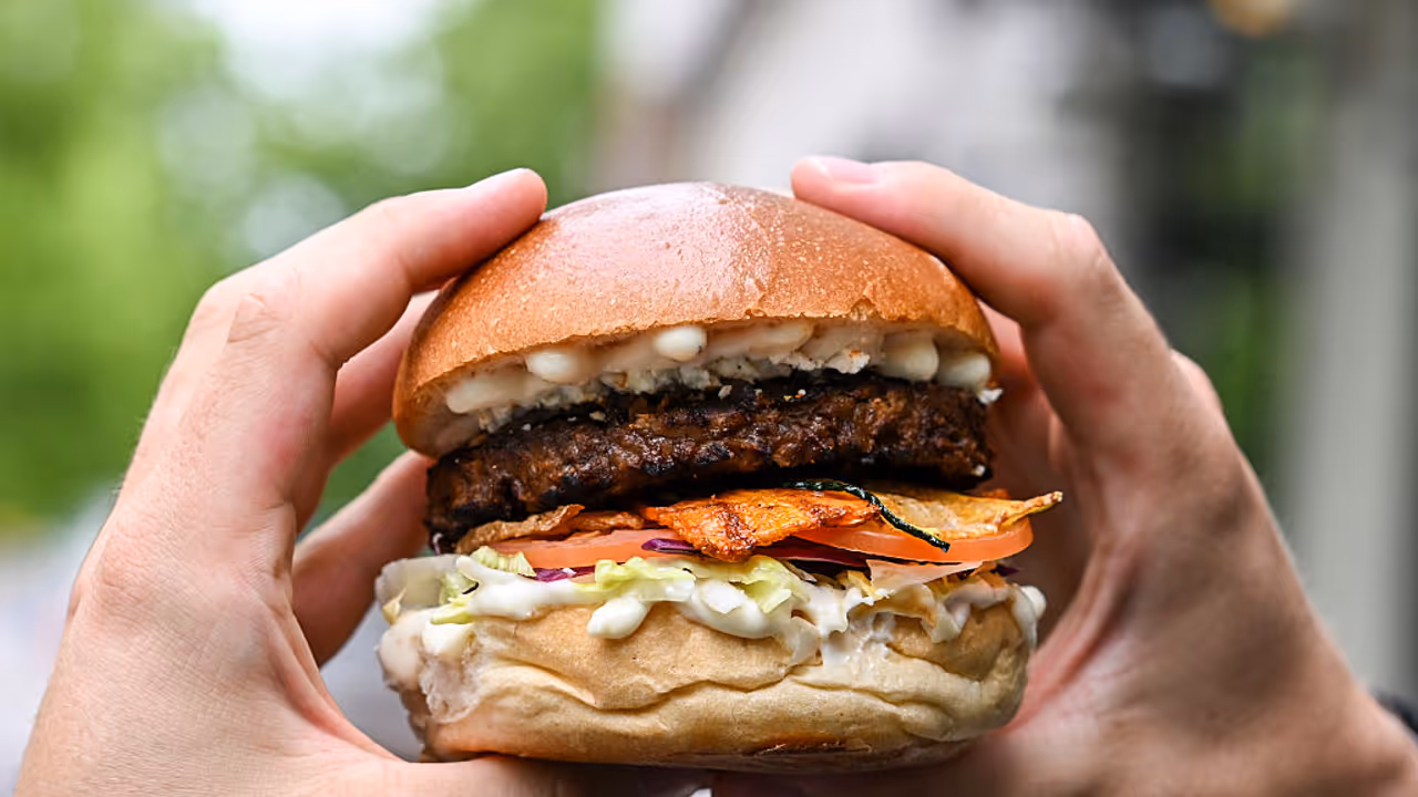The vegetarian burger "Tiergarten Burger" is held in the hands of a man in Berlin's Hard Rock Cafe. The vegetarian burger "Tiergarten Burger" is held in the hands of a man in Berlin's Hard Rock Cafe.