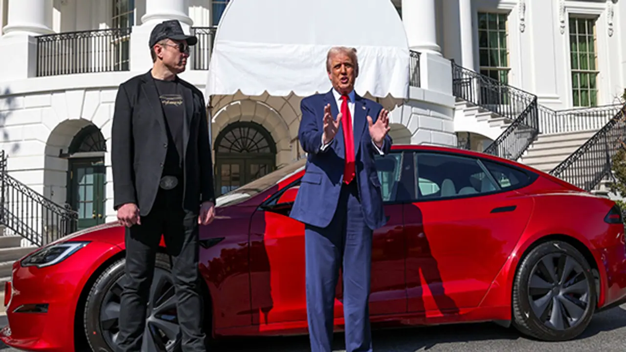 US President Donald Trump and Tesla CEO Elon Musk with a Tesla car in the background (Image Credit: Reuters)