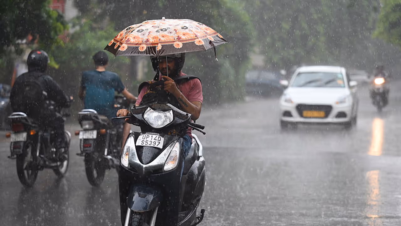 A commuter riding through rain in Delhi