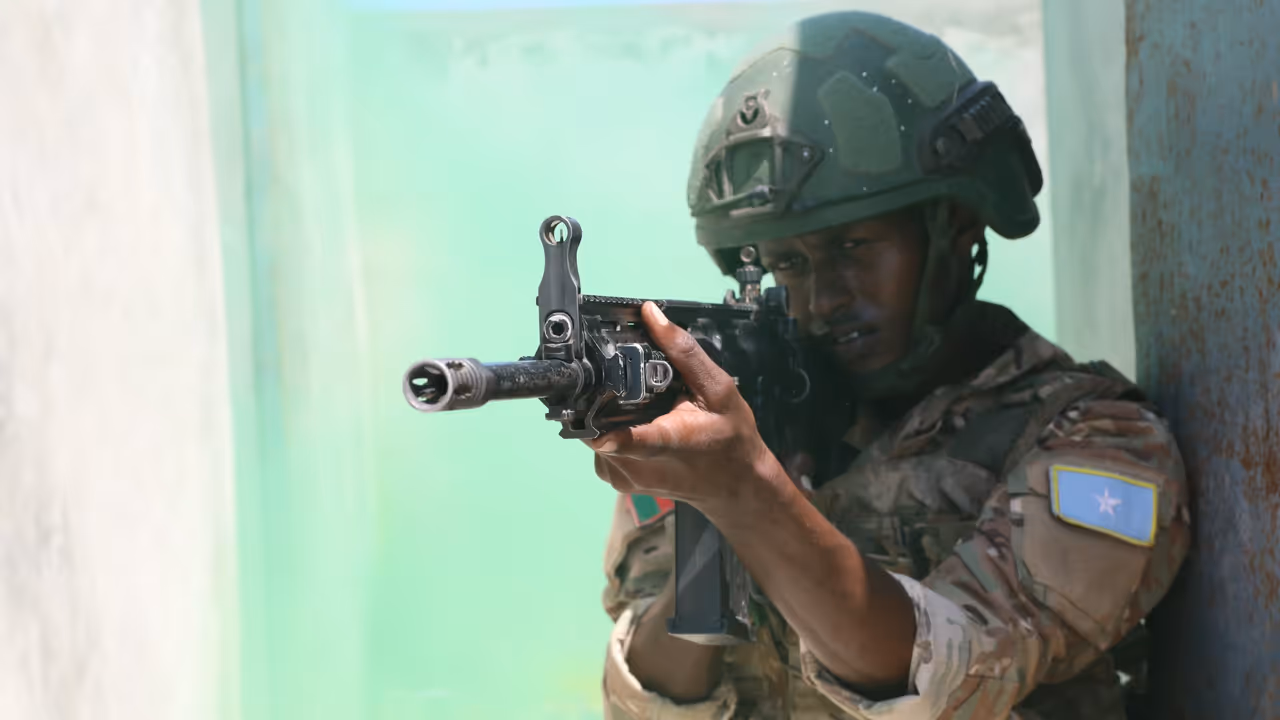 A Somali soldier aims a weapon during military training.