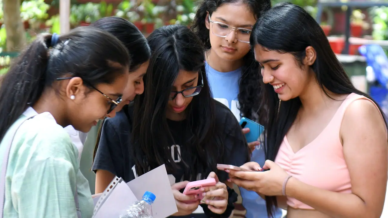 Students check their CBSE 12th board results on their mobile phones