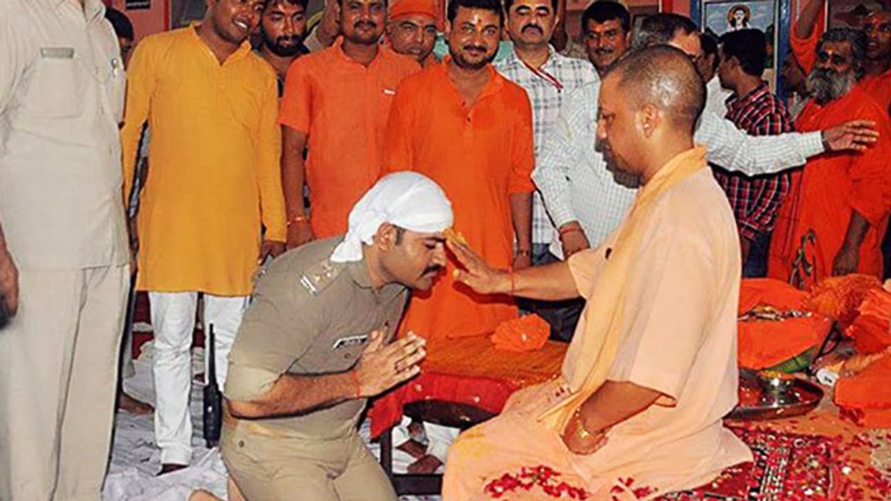 Policeman in uniform kneels before Adityanath to seek blessings, photos go viral Policeman in uniform kneels before Adityanath to seek blessings, photos go viral