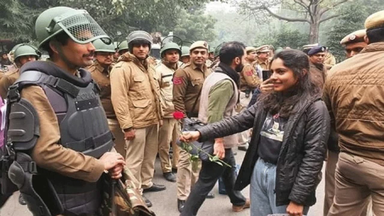 हिंसा के बीच आई एक अच्छी तस्वीर, लड़की पुलिसकर्मियों को मुस्कुराते हुए दे रही थी गुलाब का फूल हिंसा के बीच आई एक अच्छी तस्वीर, लड़की पुलिसकर्मियों को मुस्कुराते हुए दे रही थी गुलाब का फूल