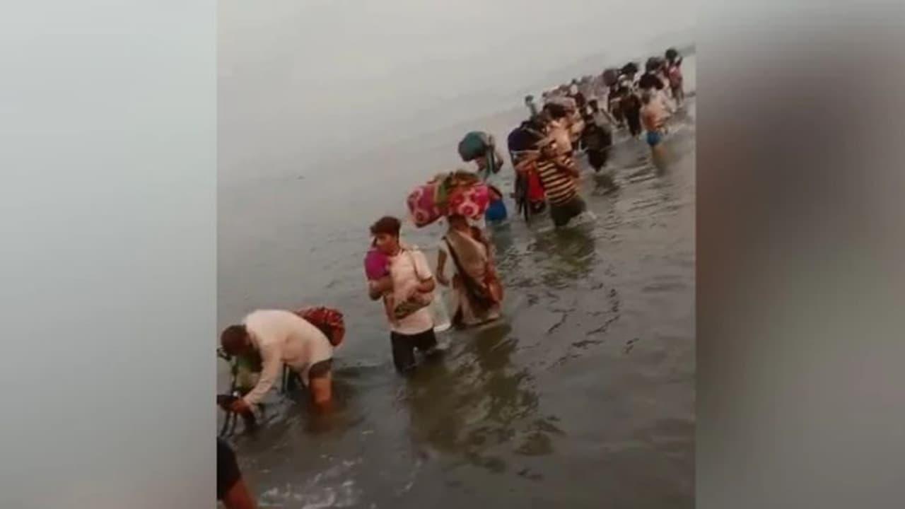 വീടെത്താന്‍ ഇനിയേത് വഴി! മുട്ടറ്റം വെള്ളമുള്ള യമുനാ നദി മുറിച്ചുകടന്ന് അതിഥി തൊഴിലാളികളുടെ യാത്ര