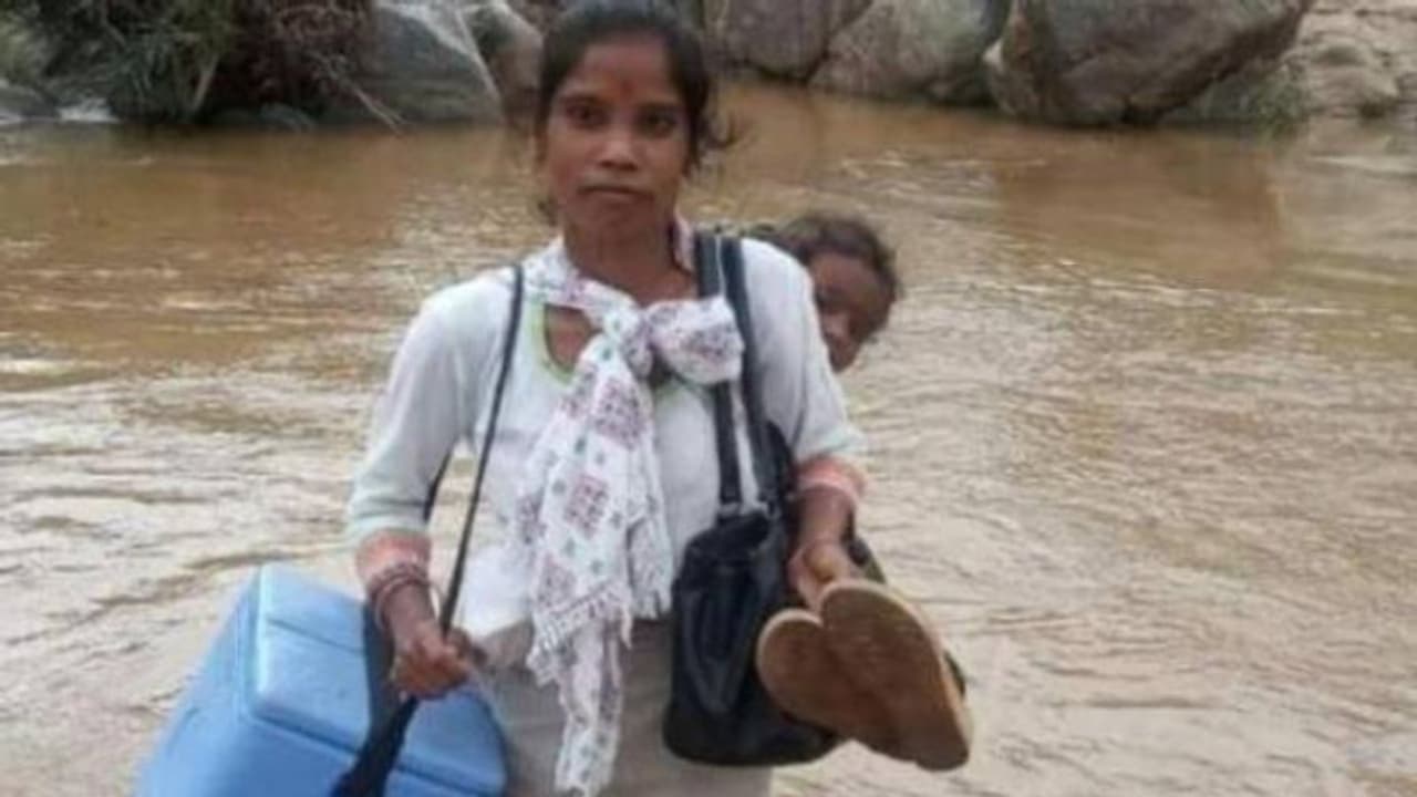 പിഞ്ചുകുഞ്ഞിനെ തോളിൽ കിടത്തി, വാക്സിൻ പെട്ടിയുമായി പുഴമുറിച്ച് കടക്കുന്ന ആരോഗ്യപ്രവർത്തക പിഞ്ചുകുഞ്ഞിനെ തോളിൽ കിടത്തി, വാക്സിൻ പെട്ടിയുമായി പുഴമുറിച്ച് കടക്കുന്ന ആരോഗ്യപ്രവർത്തക