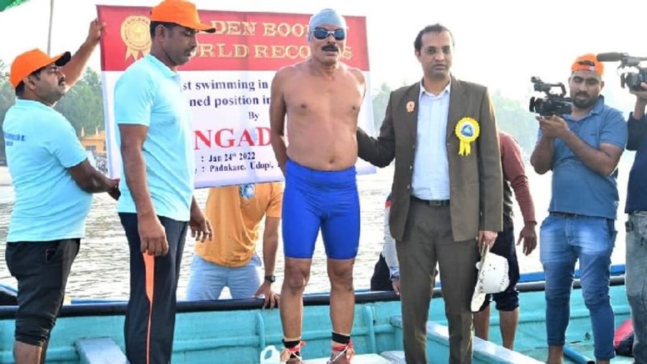 Golden Book of World Record: ಕೈಗೆ ಕೋಳ, ಕಾಲಿಗೆ ಸರಪಳಿ ಬಿಗಿದು ಈಜಿ ದಾಖಲೆ ಬರೆದ 65 ವರ್ಷದ ಗಂಗಾಧರ್