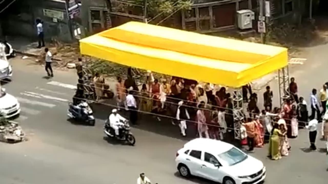 ಬಿಸಿಲಿನ ತಾಪ ತಾಳಲಾರದೆ ಪೆಂಡಾಲ್ ಜೊತೆಯಲ್ಲೇ ಸಾಗಿದ ಮದುವೆ ಮೆರವಣಿಗೆ! ಬಿಸಿಲಿನ ತಾಪ ತಾಳಲಾರದೆ ಪೆಂಡಾಲ್ ಜೊತೆಯಲ್ಲೇ ಸಾಗಿದ ಮದುವೆ ಮೆರವಣಿಗೆ!