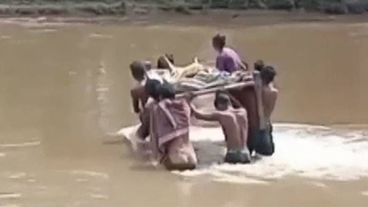 പാമ്പുകടിയേറ്റ ആദിവാസി സ്ത്രീയെ കട്ടിലിൽ ചുമന്ന് ആശുപത്രിയിലേക്ക് സാഹസിക യാത്ര പാമ്പുകടിയേറ്റ ആദിവാസി സ്ത്രീയെ കട്ടിലിൽ ചുമന്ന് ആശുപത്രിയിലേക്ക് സാഹസിക യാത്ര