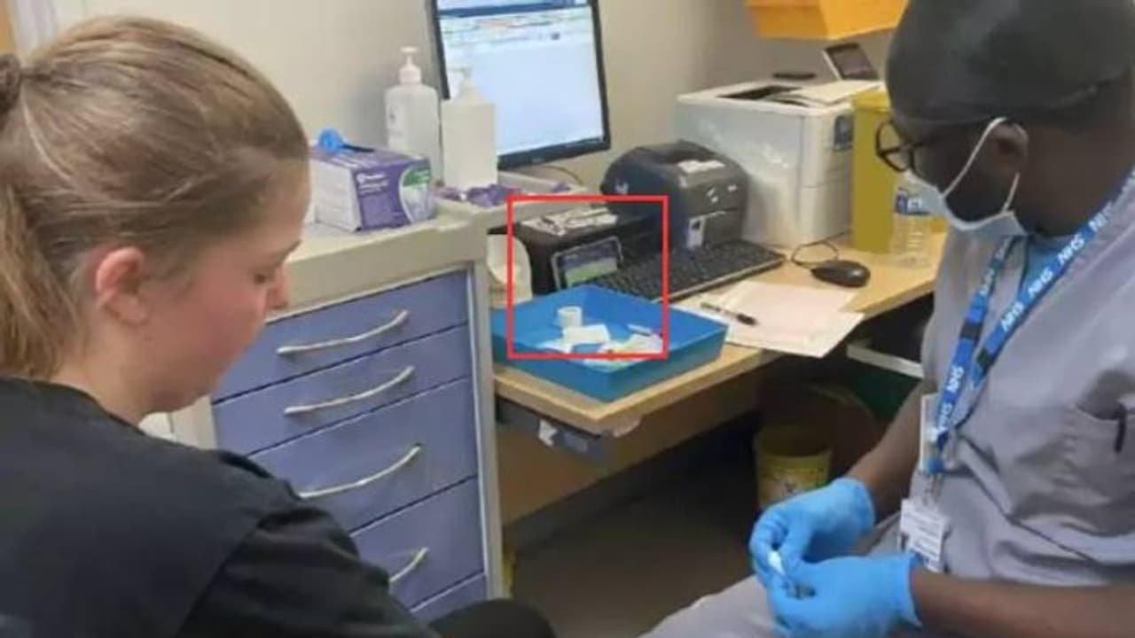 രോ​ഗിയുടെ കയ്യിൽ നിന്നും രക്തമെടുക്കുന്നതിനിടെ ഫുട്ബോൾ മത്സരം കാണുന്ന നഴ്സ്, സംഭവം വൂൾവിച്ചിൽ, വൈറലായി ചിത്രം