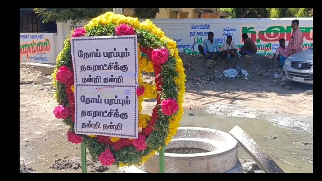 கோவிலுக்கு செல்லும் பாதையில் பெருக்கெடுத்த கழிவுநீர்; மலர்வளையம் வைத்து போராடிய மக்கள்