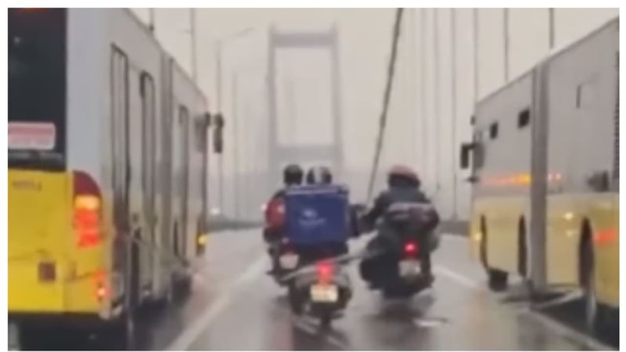 അവർ യഥാർത്ഥ നായകർ; വീശിയടിക്കുന്ന കൊടുങ്കാറ്റിൽ നിന്നും പാലം കടക്കാൻ ഡെലിവറി ബോയിസിനെ സഹായിക്കുന്ന രണ്ടുബസുകൾ