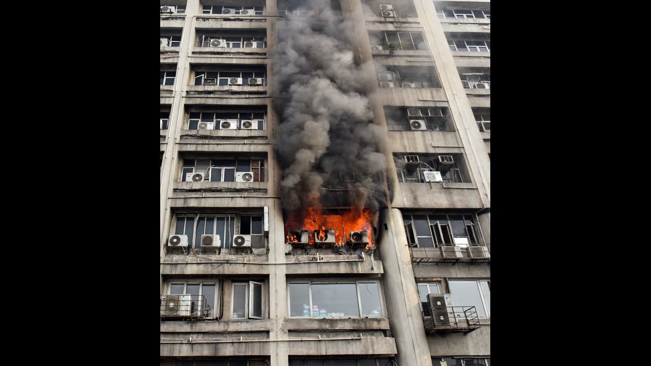 Dark smoke billows out after a fire breaks out in the Krishna building