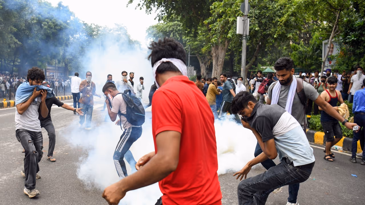 Protestors cover their face as security personnel fire tear gas shells on them during their protest march towards Parliament (File Photo/ANI) Protestors cover their face as security personnel fire tear gas shells on them during their protest march towards Parliament (File Photo/ANI)
