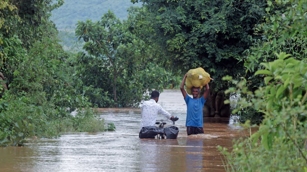 People wade through a flood water of the Mahanadi river entered the villages below Cuttack and Banki districts in Odisha (Photo/ANI) People wade through a flood water of the Mahanadi river entered the villages below Cuttack and Banki districts in Odisha (Photo/ANI)