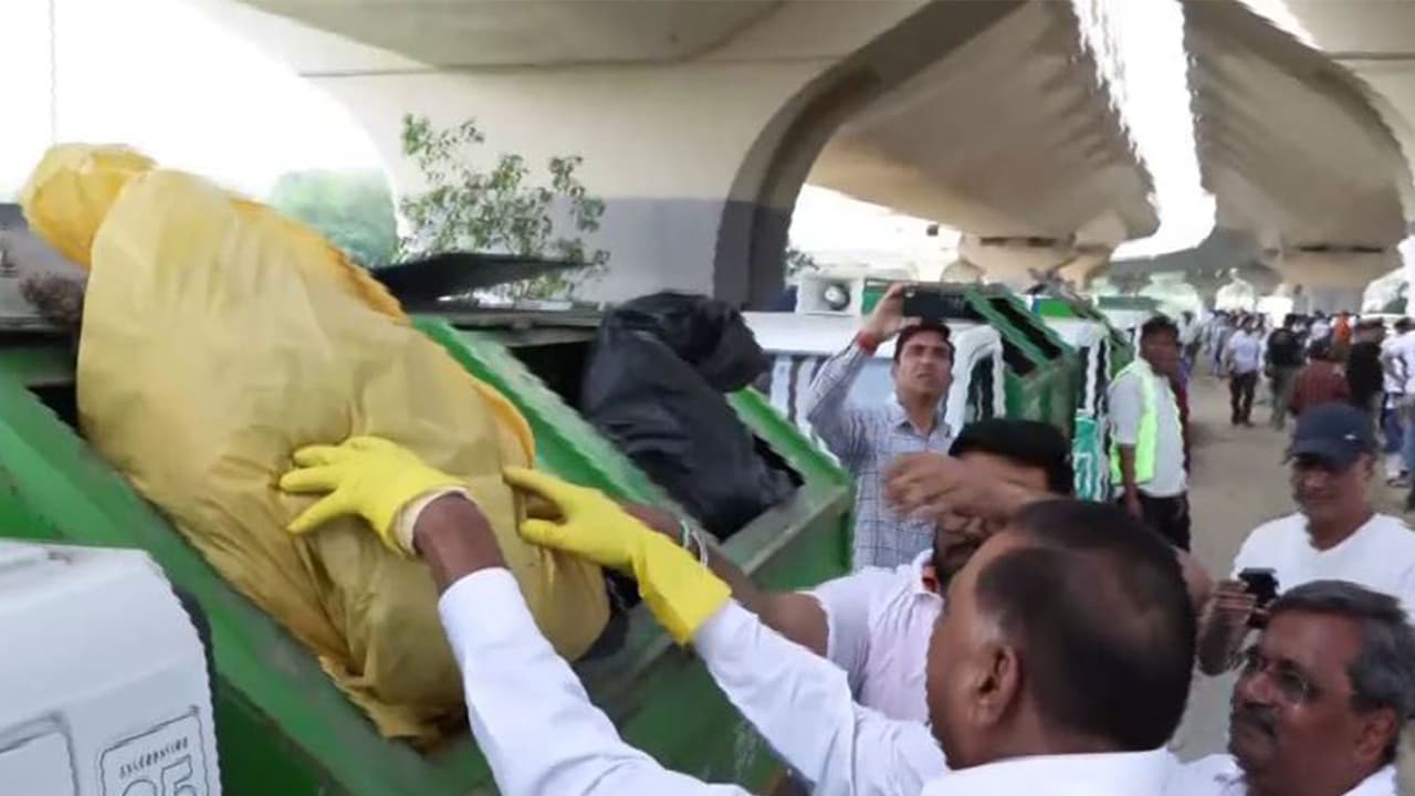 BJP leaders Ramvir Singh Bidhuri and Satish Upadhyay dispose of collected waste in a garbage truck during Yamuna cleanliness drive at Sarai Kale Khan (Photo/ANI) BJP leaders Ramvir Singh Bidhuri and Satish Upadhyay dispose of collected waste in a garbage truck during Yamuna cleanliness drive at Sarai Kale Khan (Photo/ANI)