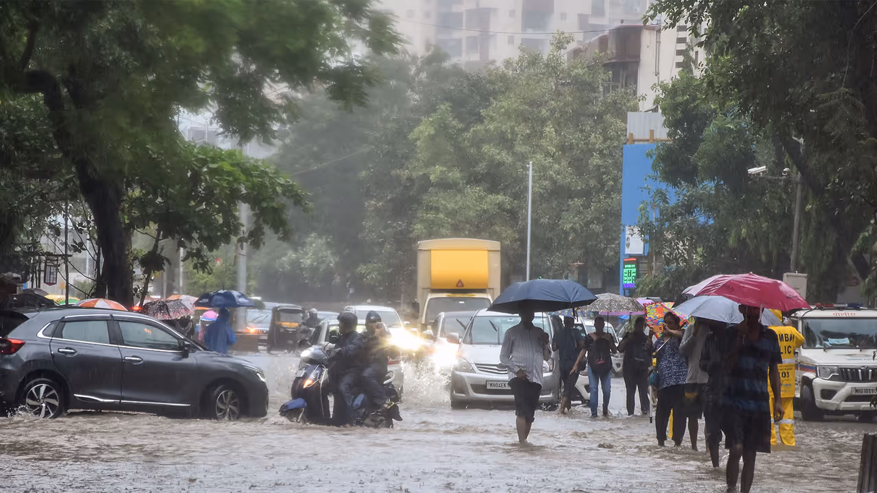 Vehicles and people wade through a waterlogged road following heavy rainfall at Andheri, in Mumbai on Saturday. (Photo/ANI) Vehicles and people wade through a waterlogged road following heavy rainfall at Andheri, in Mumbai on Saturday. (Photo/ANI)