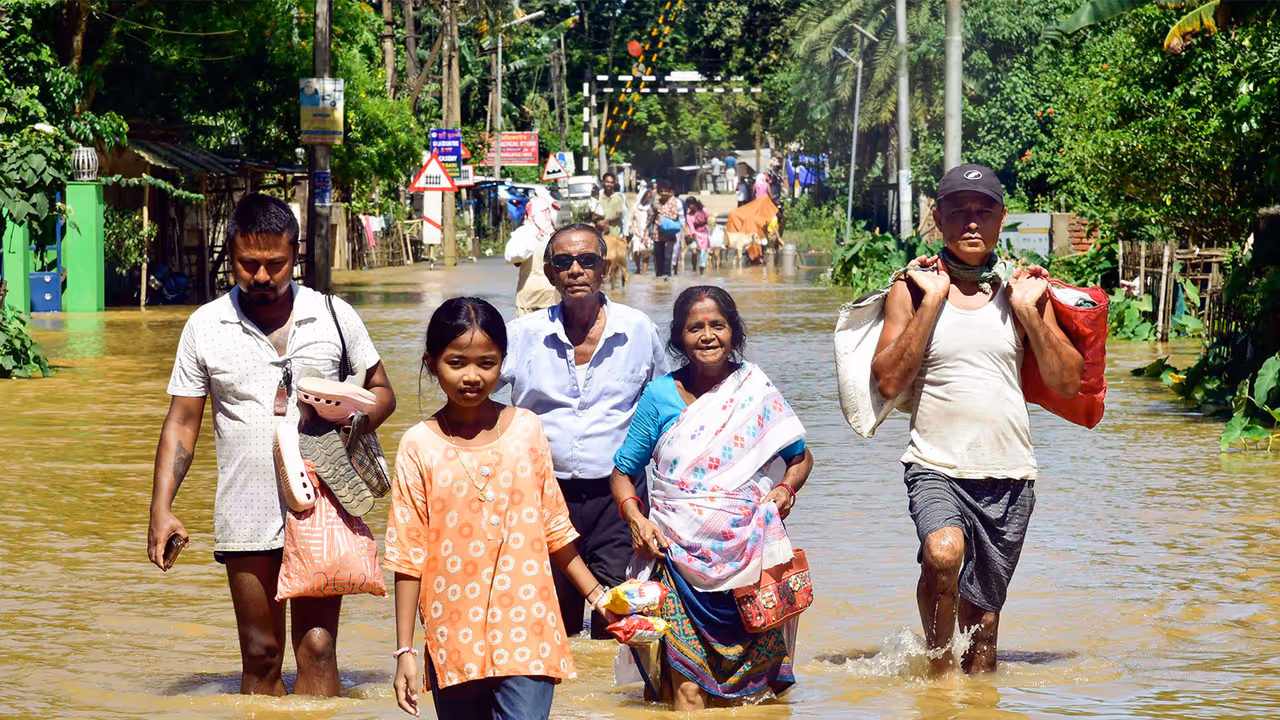 People moving to safer places carrying their belongings in a flood affected area (File Photo/ANI) People moving to safer places carrying their belongings in a flood affected area (File Photo/ANI)