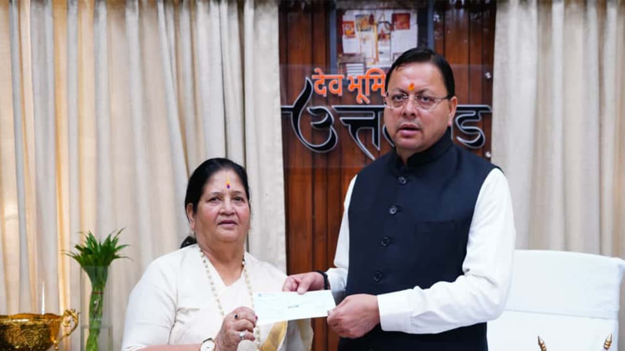On Bachendri Pal's behalf Vice Chairperson of State Women’s Entrepreneurship Council Vinod Uniyal handed over ₹10 lakh cheque to CM Dhami (Photo/ANI)