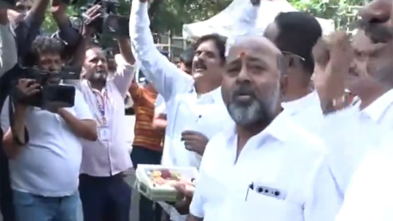 Supporters of Karnataka Deputy Chief Minister DK Shivakumar distribute sweets outside his residence (Photo/ANI) Supporters of Karnataka Deputy Chief Minister DK Shivakumar distribute sweets outside his residence (Photo/ANI)