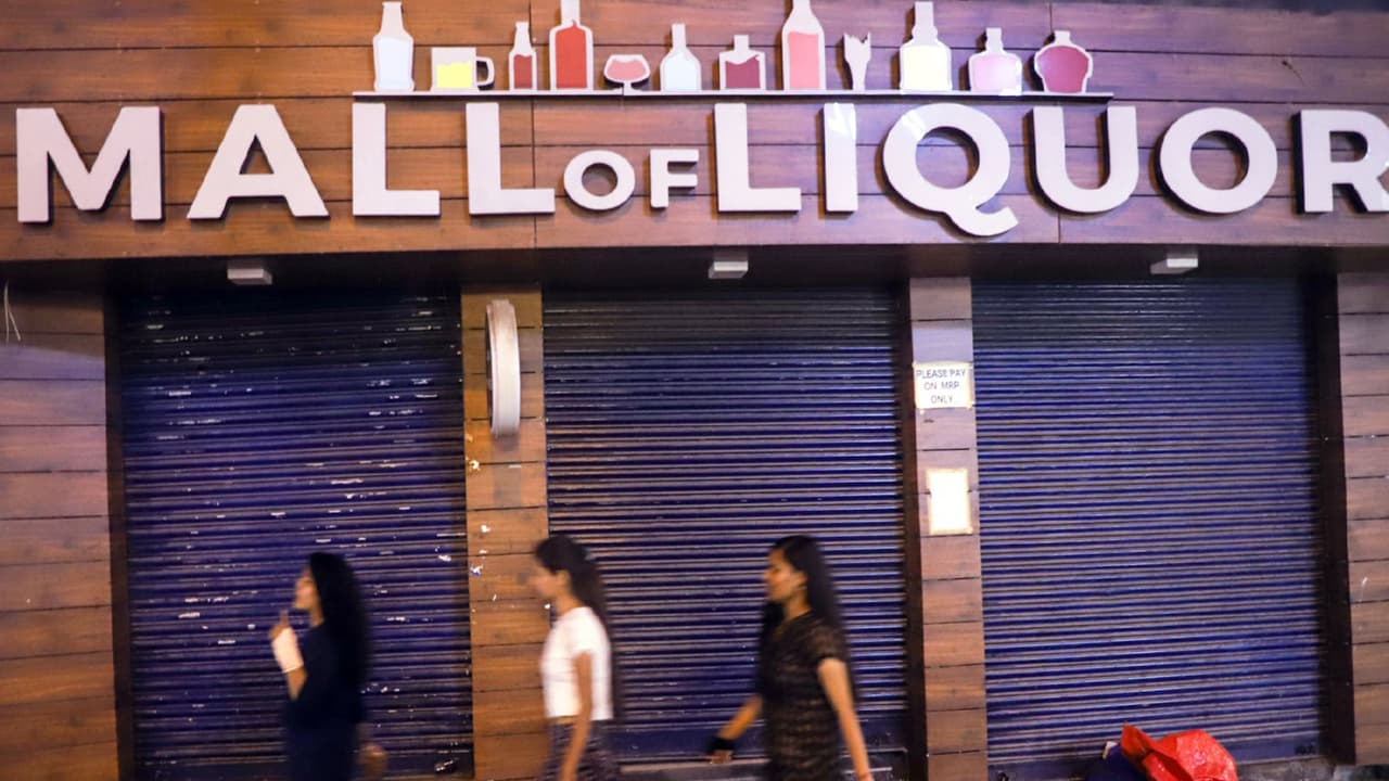 People walk past a closed liquor shop at GTB Nagar (File Photo/ANI) People walk past a closed liquor shop at GTB Nagar (File Photo/ANI)