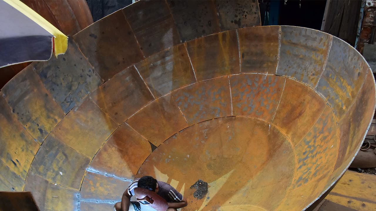 A labourer welding a giant iron pot at an iron factory in Kolkata (File Photo/ANI) A labourer welding a giant iron pot at an iron factory in Kolkata (File Photo/ANI)