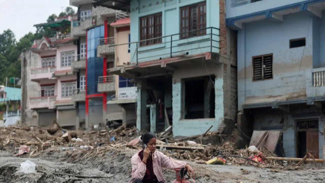 A woman speaks on a phone as she sits next to a gas cylinder at the site of flash floods and mudslides, in Devighat (File Photo/ANI) A woman speaks on a phone as she sits next to a gas cylinder at the site of flash floods and mudslides, in Devighat (File Photo/ANI)