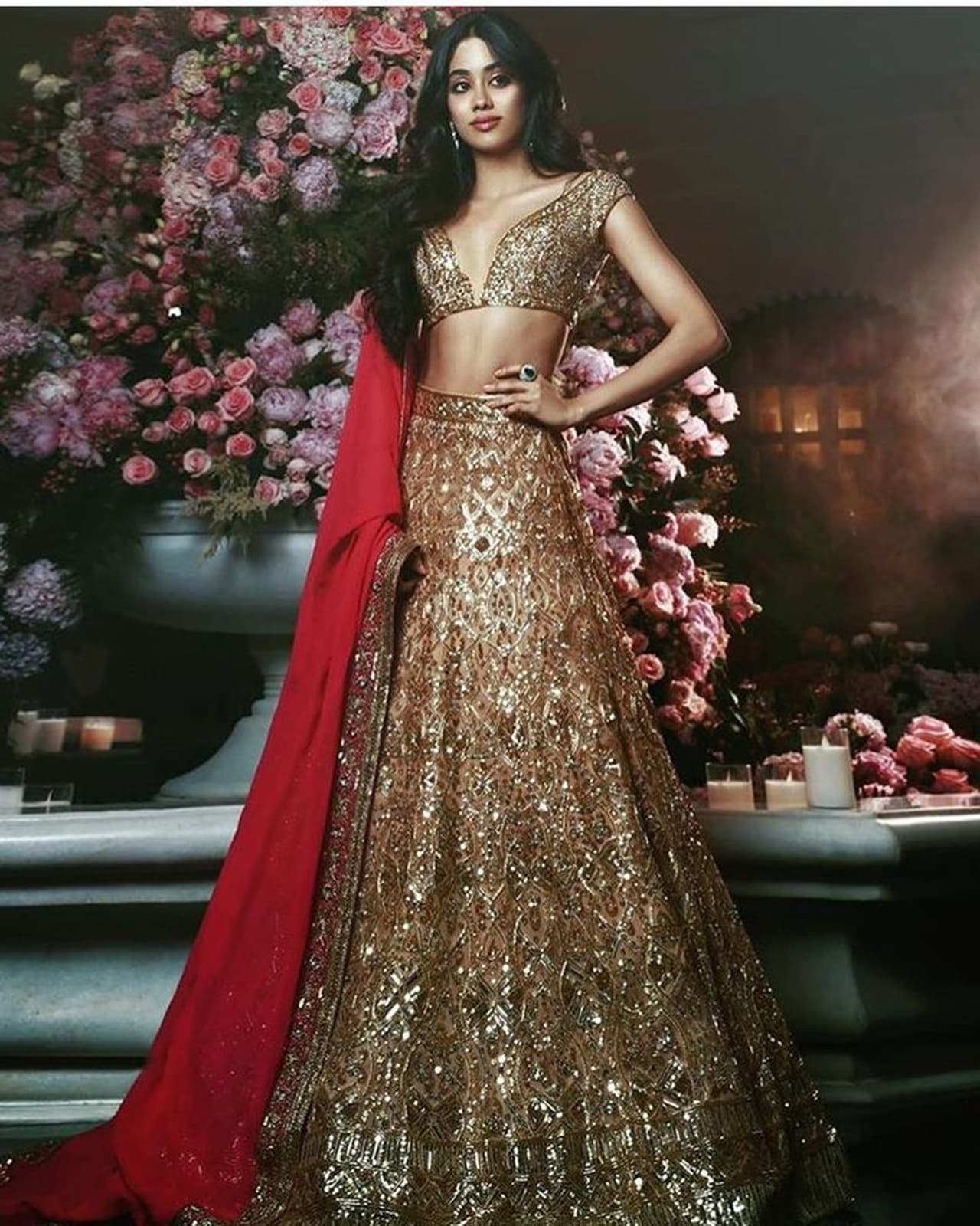 गोल्डन कलर के लहंगे और रेड कलर के दुप्पटे में बहुत खूबसूरत लग रही हैं जाह्नवी। ये उनका ईशा अंबानी की शादी की प्री वेडिंग सेरेमनी का लुक है।