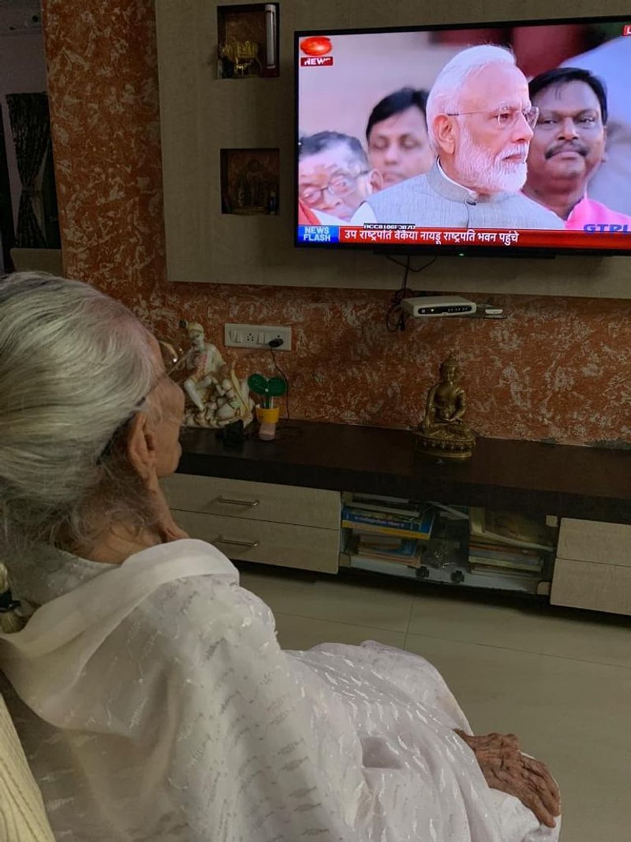 ഗുജറാത്തിലെ വീട്ടിലിരുന്നു മകന്റെ രണ്ടാംവരവ് നേരിട്ടുകണ്ട ഹീരബെന് മോദി സത്യപ്രതിജ്ഞ ചെയ്യുമ്പോള് കൈ അടിച്ച് അത് ആഘോഷമാക്കി. നേരത്തെ തന്നെ നിരവധി ചാനലുകള് ഹീരബെനിന്റെ വീട്ടില് എത്തിയിരുന്നു. വാര്ത്ത ഏജന്സി എഎന്ഐ സത്യപ്രതിജ്ഞ കാണുന്ന ഹീരബെന്നിന്റെ ചിത്രങ്ങള് പുറത്തുവിട്ടു. ഗുജറാത്തിലെ വീട്ടിലിരുന്നു മകന്റെ രണ്ടാംവരവ് നേരിട്ടുകണ്ട ഹീരബെന് മോദി സത്യപ്രതിജ്ഞ ചെയ്യുമ്പോള് കൈ അടിച്ച് അത് ആഘോഷമാക്കി. നേരത്തെ തന്നെ നിരവധി ചാനലുകള് ഹീരബെനിന്റെ വീട്ടില് എത്തിയിരുന്നു. വാര്ത്ത ഏജന്സി എഎന്ഐ സത്യപ്രതിജ്ഞ കാണുന്ന ഹീരബെന്നിന്റെ ചിത്രങ്ങള് പുറത്തുവിട്ടു.