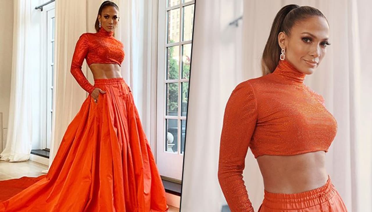 Jennifer Lopez attended the CFDA Fashion Awards last night (June 4) and set the red carpet on fire. The singer, songwriter and actress showed off her perfect abs in an orange two piece Ralph Lauren number.