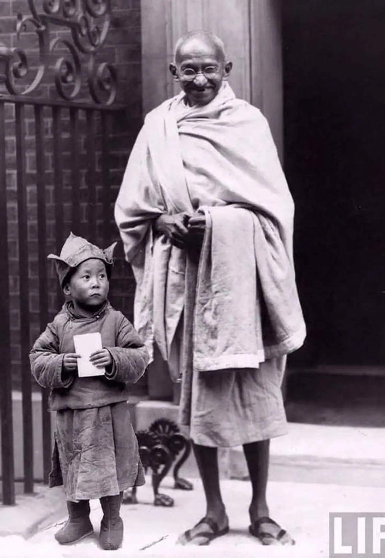 குழந்தையின் அருகே நிற்கும் காந்தி