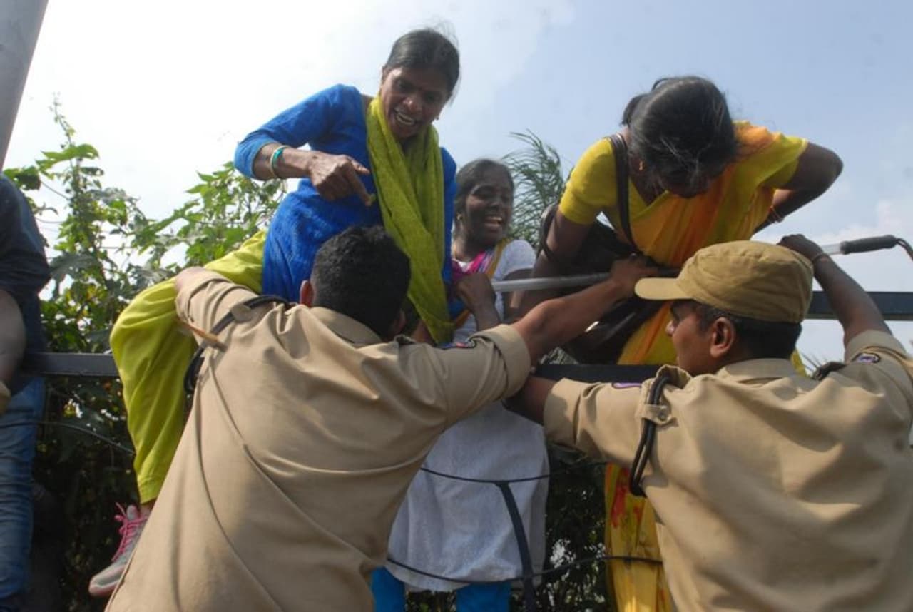 బారికేడ్లను దూకేందుకు ప్రయత్నిస్తున్న మహిళా కార్మికులు బారికేడ్లను దూకేందుకు ప్రయత్నిస్తున్న మహిళా కార్మికులు
