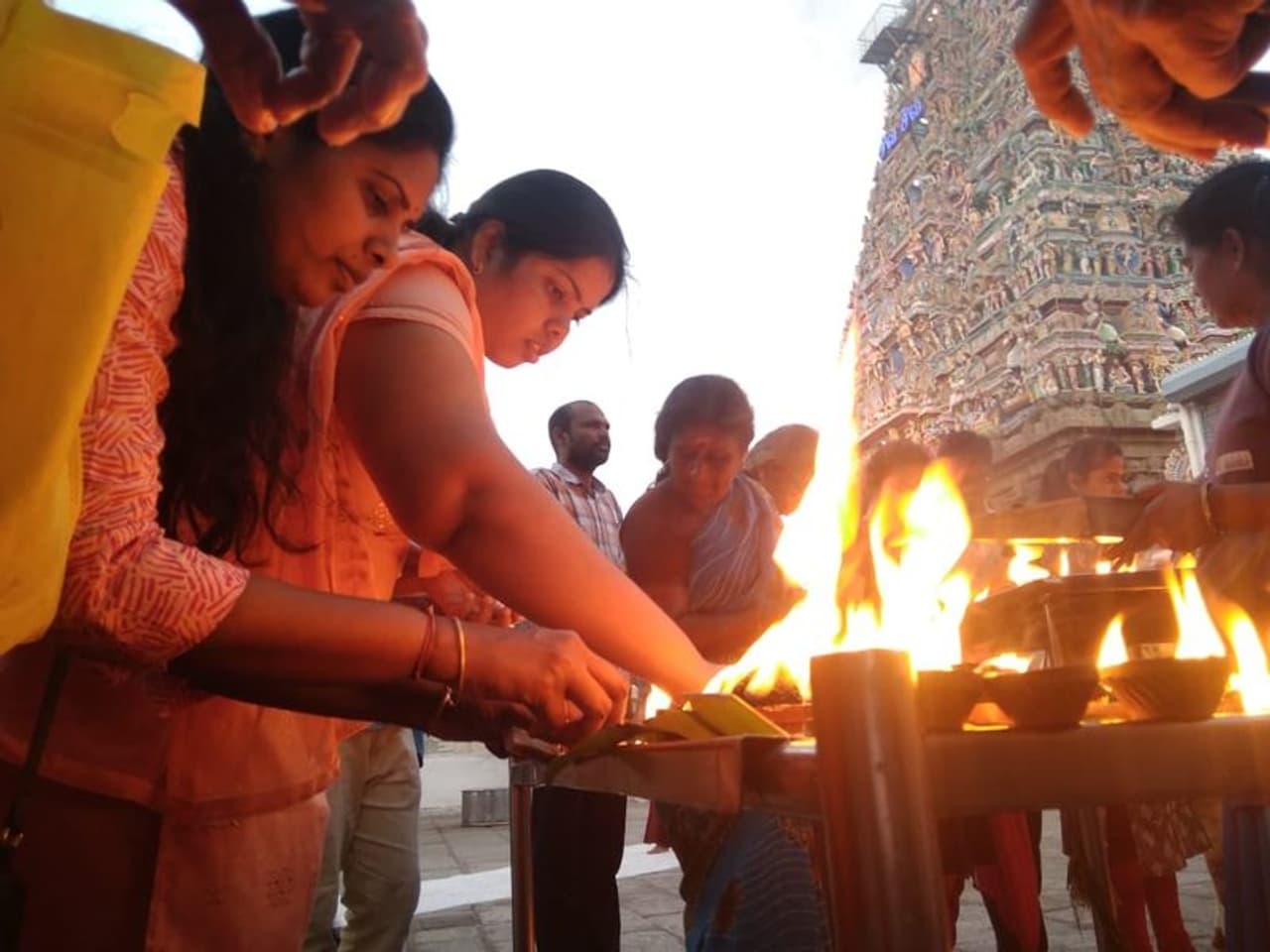 பயபக்தியோடு கோவிலில் விளக்கேற்றும் பெண்கள்