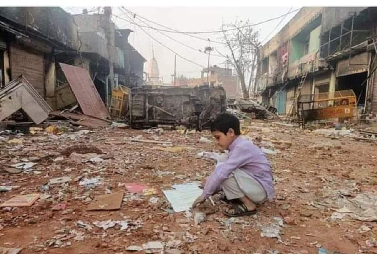 ദില്ലി കലാപത്തിന്‍റെ ബാക്കി പത്രം. കലാപകാരികള്‍ കത്തിച്ചു കളഞ്ഞ പാഠപുസ്തകങ്ങളില്‍ അവശേഷിച്ചവ കണ്ടെത്താന്‍ ശ്രമിക്കുന്ന കുട്ടി.