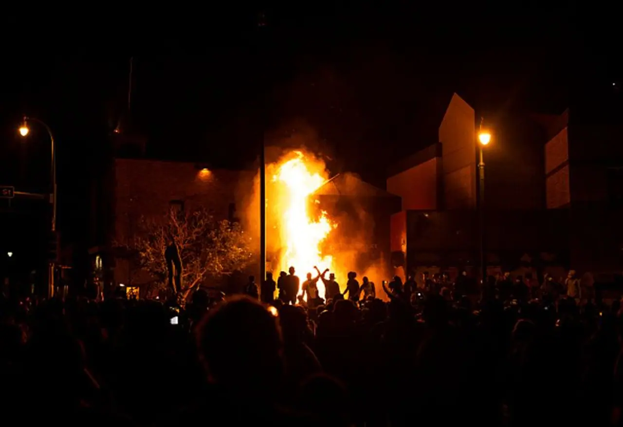 <p>Protesters cheer as the Third Police Precinct burns behind them on May 28 in Minneapolis, Minnesota.</p>