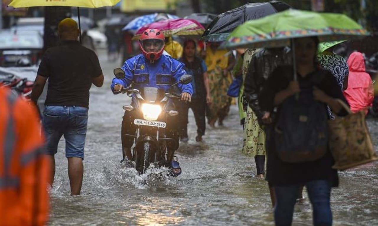<I>Image: People wade through a water logged street following monsoon rains, in Mumbai, Tuesday, July 5, 2022. Photograph: PTI Photo/Kunal Patil</I> <I>Image: People wade through a water logged street following monsoon rains, in Mumbai, Tuesday, July 5, 2022. Photograph: PTI Photo/Kunal Patil</I>