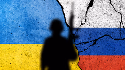 Flag of Ukraine and Russia painted on a brick wall with soldiers