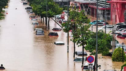 Flooded roads and submerged vehicles in central Vietnam amid heavy rains.