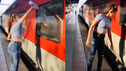 woman cleaning window of train then littering trash on tracks video