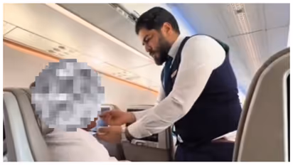saudia airlines crew member feeding elderly passenger