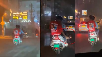 crackers on a busy road while riding a scooter