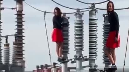 Woman climbs high voltage wires