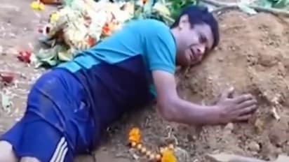 Father cries over grave of son 