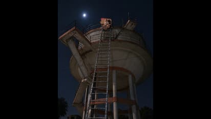 Woman Climbs Overhead Water Tank